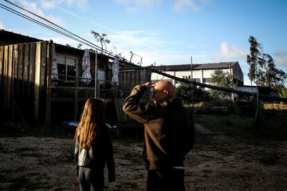Un hombre y una niña miran una casa dañada por la caída de un árbol en Figueira da Foz, Portugal, el 14 de octubre de 2018. 
