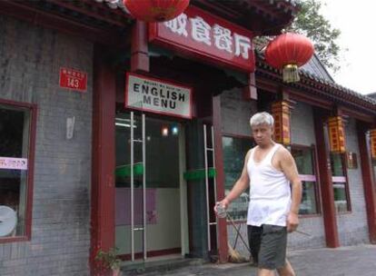 Restaurante en el centro de Pekín con un cartel sobre la puerta que ofrece la carta en inglés.