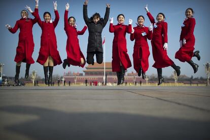 Un grupo de acomodadores saltaa mientras posan para una foto durante una reunión previa a la sesión de apertura del Congreso Nacional Popular de China (APN) en el Gran Palacio del Pueblo en Pekín.