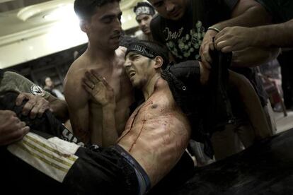 Un rebelde herido es transportado hacia un refugio durante los combates en el barrio de Midan, en Alepo.