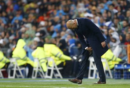Zidane observa un roto que se hizo en el pantalón.
