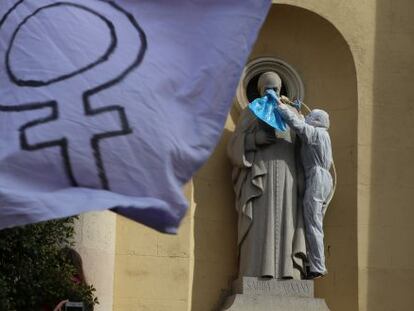 Una activista coloca una soga al cuello de la estatua de  un santo en una iglesia de Sabadell.