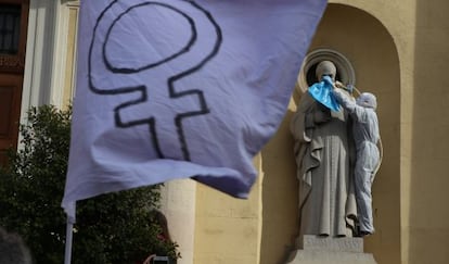 Una activista coloca una soga al cuello de la estatua de  un santo en una iglesia de Sabadell.