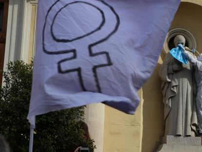 Una activista coloca una soga al cuello de la estatua de  un santo en una iglesia de Sabadell.