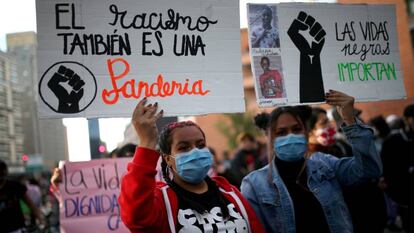 Dos mujeres sostienen pancartas contra el racismo en una de las protestas generadas en todo el mundo tras el asesinato del estadounidense George Floyd a manos de la policía. En Bogotá, Colombia, el 15 de junio de 2020.  