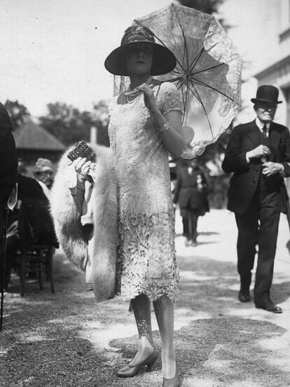 Vestido blanco de encaje de Guipur con sombrilla a juego.