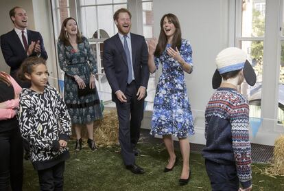 El principe Guillermo (izqda.), el príncipe Enrique (2º izqda.) y la duquesa Catalina (drcha.), sonríen durante un acto con niños y representantes de organizaciones benéficas en Londres (Reino Unido).