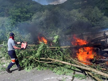 A protester pours fuel onto a flaming roadblock in Pozo Santiago de Aller, Asturias. 