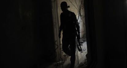 Un rebelde camina entre los escombros de un edificio en Aleppo.