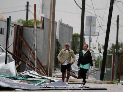 Turistas caminan entre los escombros que cubren la calle después de la llegada del huracán Zeta a Playa del Carmen, México