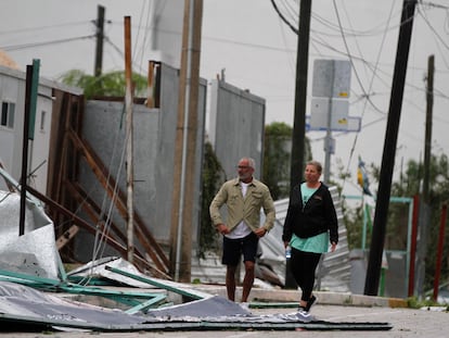 Turistas caminan entre los escombros que cubren la calle después de la llegada del huracán Zeta a Playa del Carmen, México