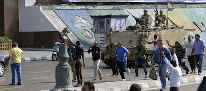 Un blindado del Ej&eacute;rcito egipcio vigila a un grupo de manifestantes contrarios a los Hermanos Musulmanes en Alejandr&iacute;a.