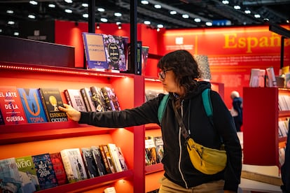 Una mujer compra libros en el área internacional de la feria. 