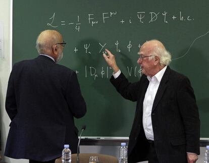 Los físicos Peter Higgs (d) y François Englert (i), que acaban de obtener el Nobel de Física, y Premios Príncipe de Asturias 2013, conversan sobre la fórmula del Bosón en una pizarra de la Facultad de Ciencias de la Universidad de Oviedo tras finalizar la conferencia que impartieron en una de las aulas.