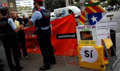 Dos mossos interroguen un membre de l'ANC que protesta per la prohibició del referèndum.