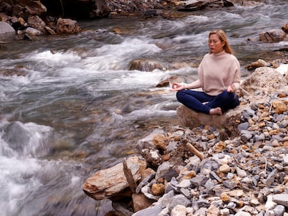 Mujer medita junto a un río