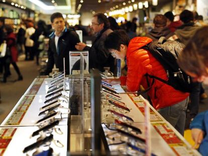 Varias personas miran móviles en una tienda Fnac de Madrid.