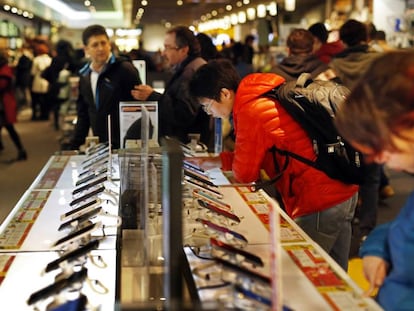 Varias personas miran móviles en una tienda Fnac de Madrid.