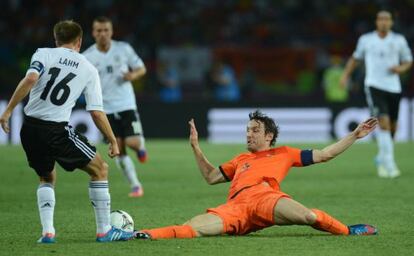 Van Bommel trata de quitarle el balón a Lahm.