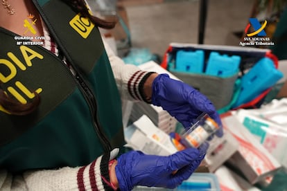 Una guardia civil sostiene uno de los fármacos intervenidos en la 'Operación Kalopsia' contra el tráfico ilegal de bótox desde Corea del Sur, en una imagen facilitada por el instituto armado.