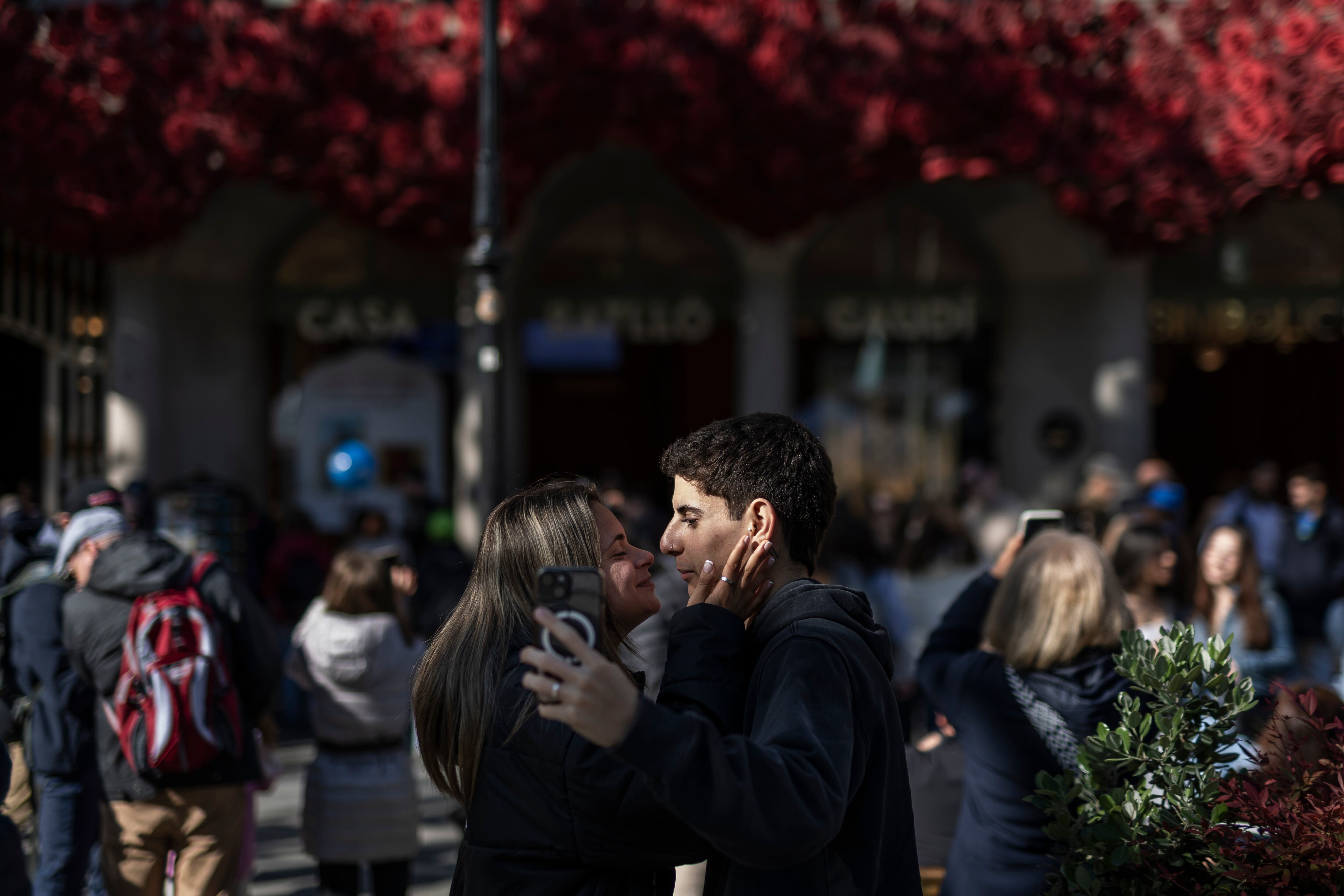 Dos jóvenes se hacen una foto mientras se besan, este martes delante de la Casa Batlló.