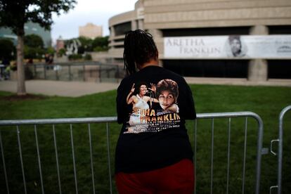 Una mujer viste una camiseta de Aretha Franklin.