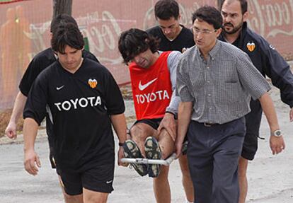 Ayala es retirado en camilla del entrenamiento de ayer del Valencia.