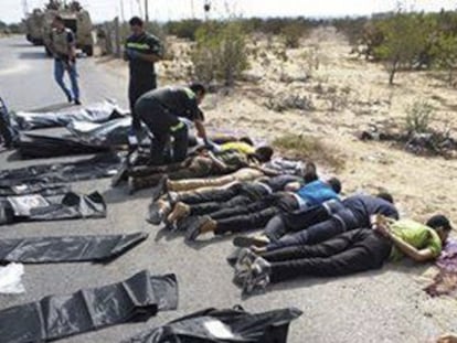 Médicos militares comprueban los cuerpos de los policías asesinados.