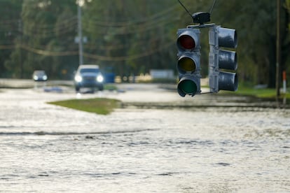 Un semáforo pende de un cable sobre una calle inundada, este jueves en Tampa, Florida.