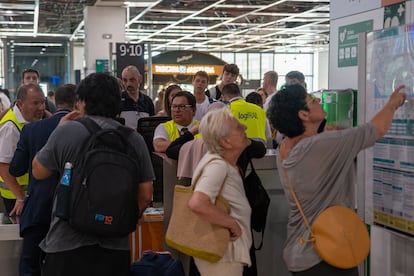 Pasajeros en la estación de Sants, buscando información sobre el horario de trenes, este lunes.