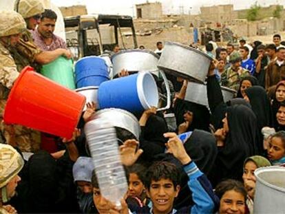 Un grupo de iraquíes se pelean por conseguir agua que reparten soldados británicos, ayer en Basora.