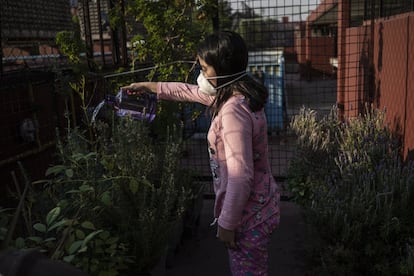 Seany Ruiz usa una mascarilla para protegerse mientras sube a regar las plantas en la azotea en Tlatelolco, en Ciudad de México.