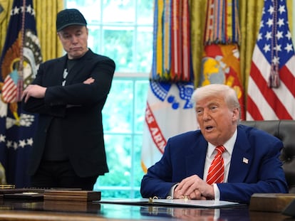 El presidente de EE UU, Donald Trump (sentado) habla mientras el magnate Elon Musk, dueño de Tesla y X, le mira.