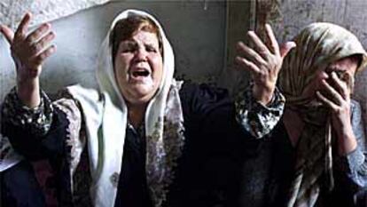 Dos mujeres palestinas lloran durante el funeral de Yeheh al Day, muertos por disparos israelíes en Gaza.
