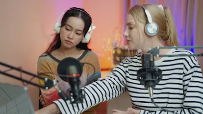 Dos periodistas se preparan para grabar un podcast.