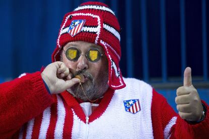 Un aficionado del Atlético en el Calderón besa (se supone) su medallita de la buena suerte.