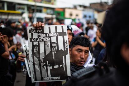 Un manifestante sostiene un cartel con un montaje de Dina Boluarte y Alberto Otárola, primer ministro de Perú, entre rejas.