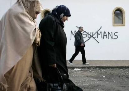 Dos mujeres musulmanas pasan ante una mezquita con una pintada insultante en Saint-Etienne.