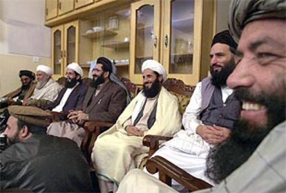 Antiguos ministros y líderes talibanes sonríen durante el anuncio, en Islamabad, de la capitulación de la resistencia militar talibán en Afganistán.