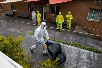 Personal de limpieza y miembros de la UME (de amarillo) realizan labores de desinfección el la residencia geriátrica Els Avets de Rubí (Barcelona).