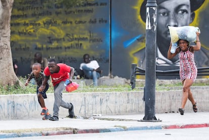 Varias personas corren para protegerse de un tiroteo cerca del Palacio Nacional en Puerto Príncipe, el pasado día 21.