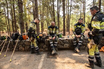 Miembros de la EIFIR se toman un descanso tras trabajar en el incendio en Las Raíces (El Rosario), este viernes.