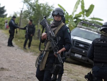 Um policial mexicano vigia as fossas de Iguala.