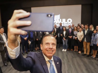 O governador João Doria tira selfie com os correspondentes.