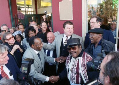 Foto de diciembre de 1999 de Dave Bartholomew (izquierda), que estrecha la mano de Fats Domino (en el centro con gafas y kepi).