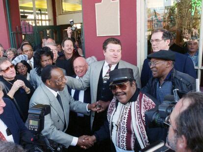 Foto de diciembre de 1999 de Dave Bartholomew (izquierda), que estrecha la mano de Fats Domino (en el centro con gafas y kepi).