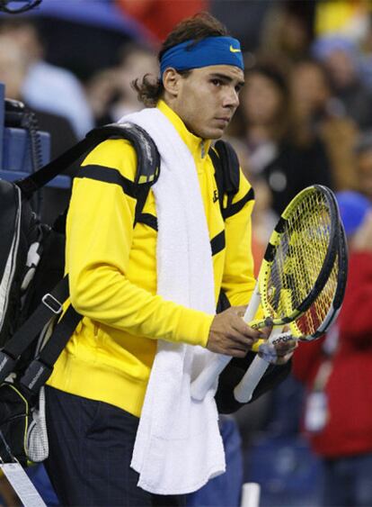 El tenista español Rafael Nadal abandona la pista después de que su partido contra el chileno Fernando González fuese suspendido por la lluvia