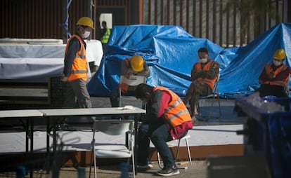 Workers, some with face masks, after the cancellation of the Mobile World Congress.