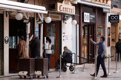 Varias personas esperan a ser atendidas, este jueves en el exterior de una cafetería de Málaga.