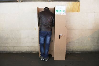 Els centres de votació estaran oberts durant vuit hores, fins a les 16.00 (21.00 GMT). A la imatge, un jove marca la seva papereta, a Bogotà.